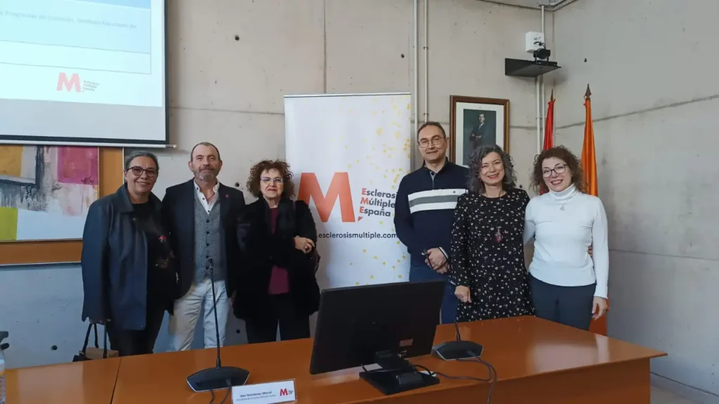 Grupo de representantes de asociaciones y profesionales asistentes a la presentación del estudio sobre la valoración de la discapacidad en España, posando junto al panel de Esclerosis Múltiple España.